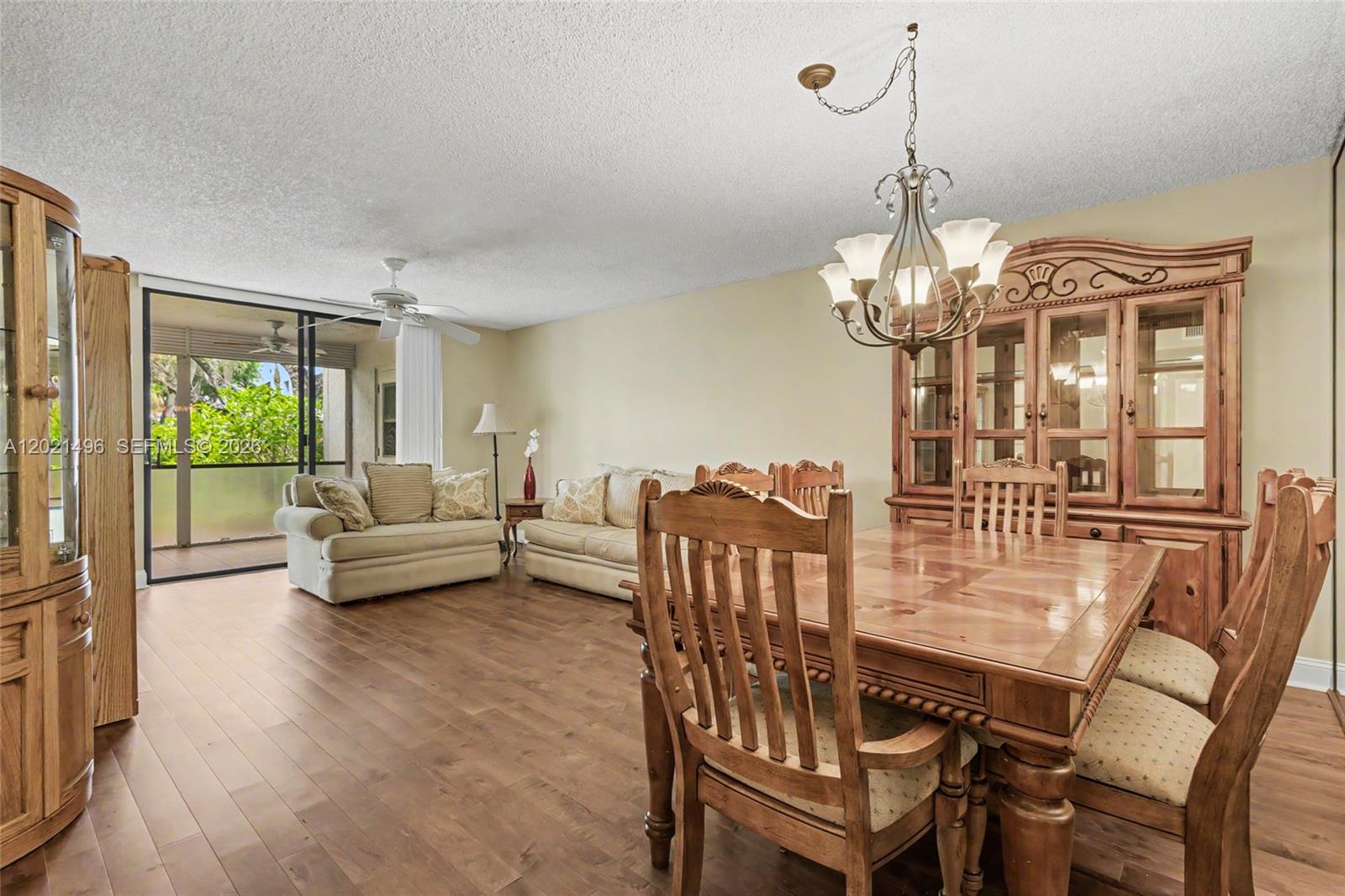 A dining area with a wooden table and hutch opens into a living room — 1420 Sheridan St # 3H, Hollywood FL 33020, HOLLYWOOD, FL