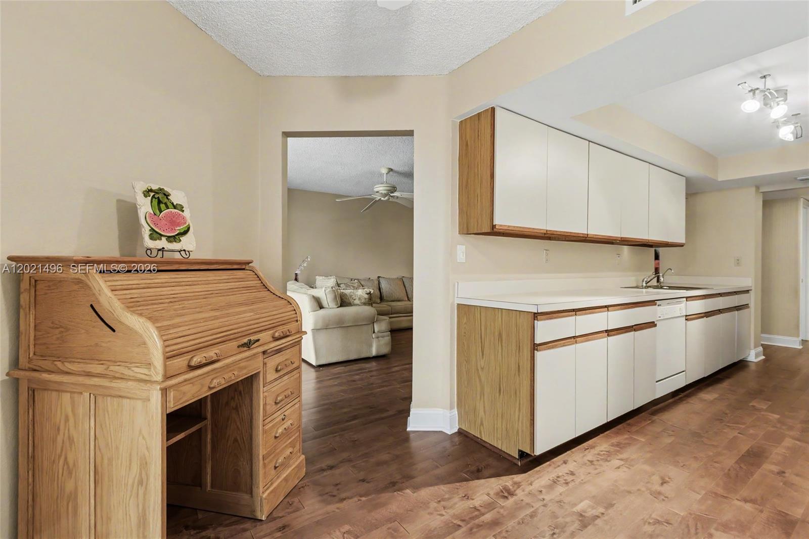 A kitchen with white cabinets, wood accents, and a roll-top desk in the foreground — 1420 Sheridan St # 3H, Hollywood FL 33020, HOLLYWOOD, FL
