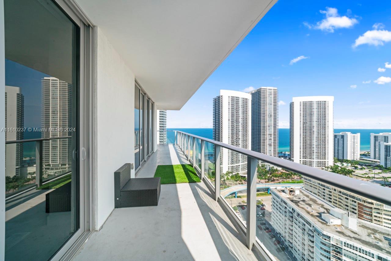 A high-rise balcony features a glass railing, artificial turf, and views of the ocean — 4010 S Ocean Dr # R2409, Hollywood FL 33019, HOLLYWOOD, FL
