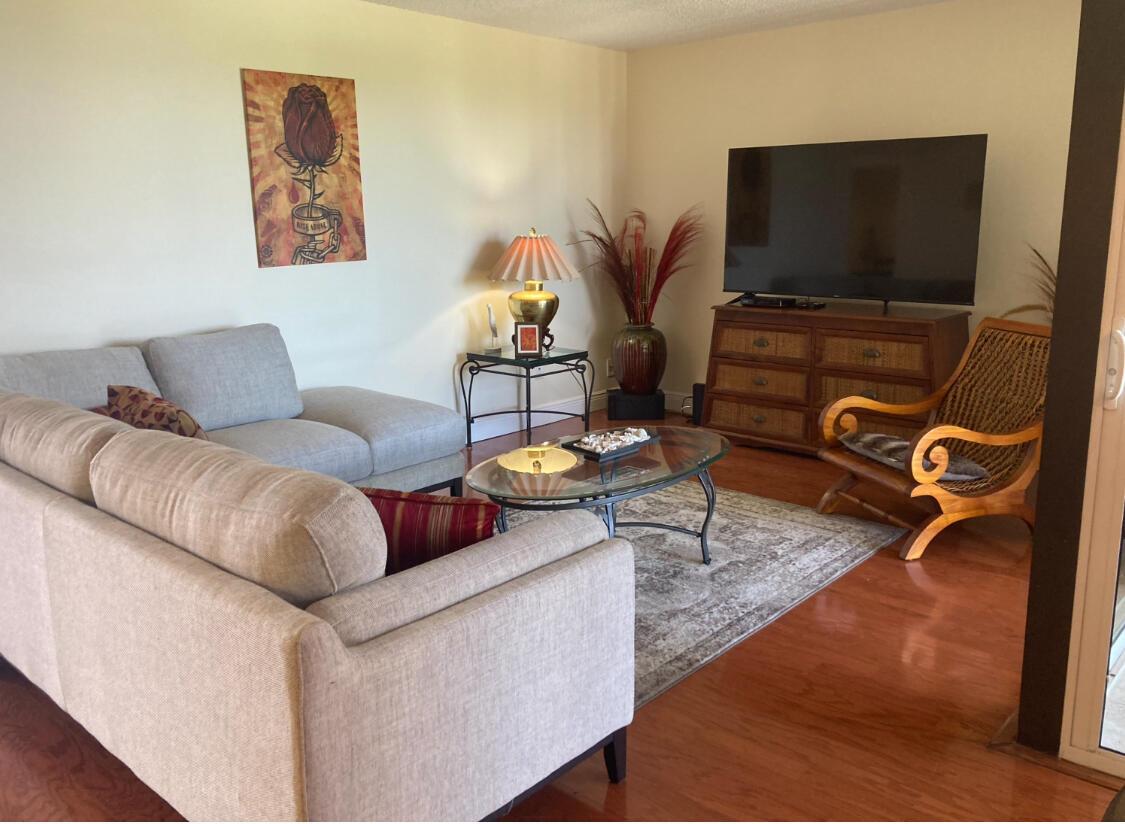 A living room features a light-colored sofa, a glass coffee table, and a television console — 2255 Lindell Boulevard # 4404, Delray Beach FL 33444, DELRAY BEACH, FL