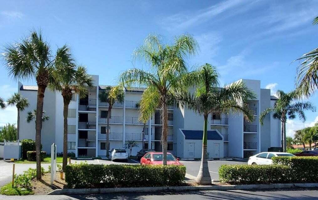 A three-story apartment building with palm trees and a parking lot in the foreground — 1605 S Us Highway 1 # F203, Jupiter FL 33477, JUPITER, FL