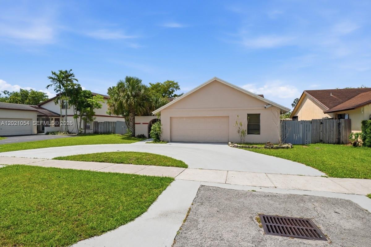 A single-story house with a beige exterior, a two-car garage, and a concrete driveway — 4080 NW 1st Pl, Deerfield Beach FL 33442, DEERFIELD BEACH, FL