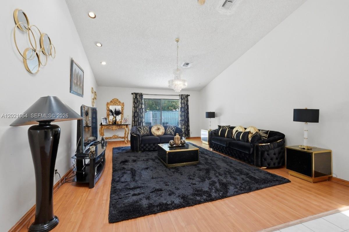 A living room features black velvet sofas, a dark rug, and gold-accented furniture — 4080 NW 1st Pl, Deerfield Beach FL 33442, DEERFIELD BEACH, FL