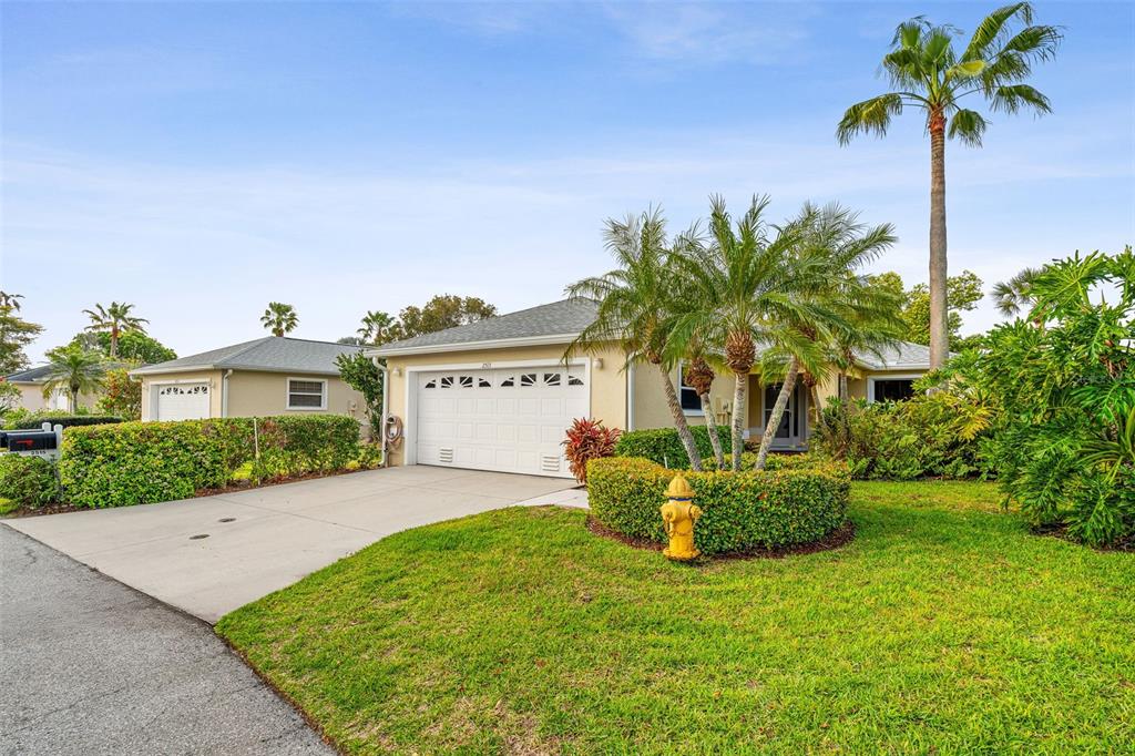 A single-story house with a white garage door, a concrete driveway, and a yellow fire hydrant — 2515 LANTANA LANE, PALMETTO, FL