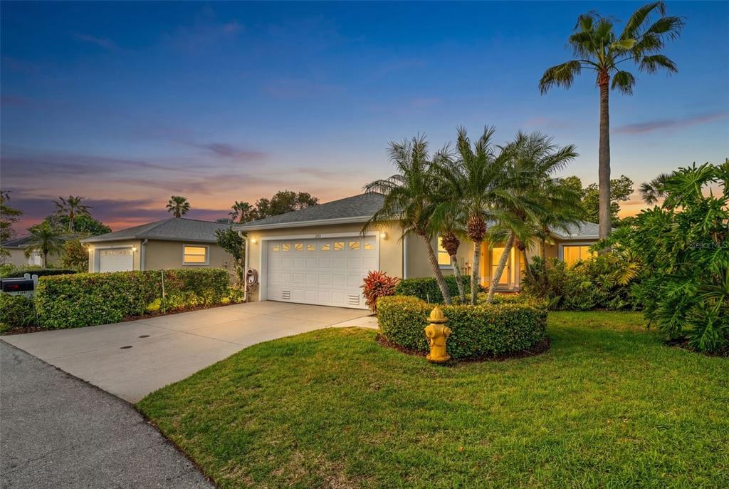 A single-story house with a white garage, palm trees, and a fire hydrant on the lawn — 2515 LANTANA LANE, PALMETTO, FL