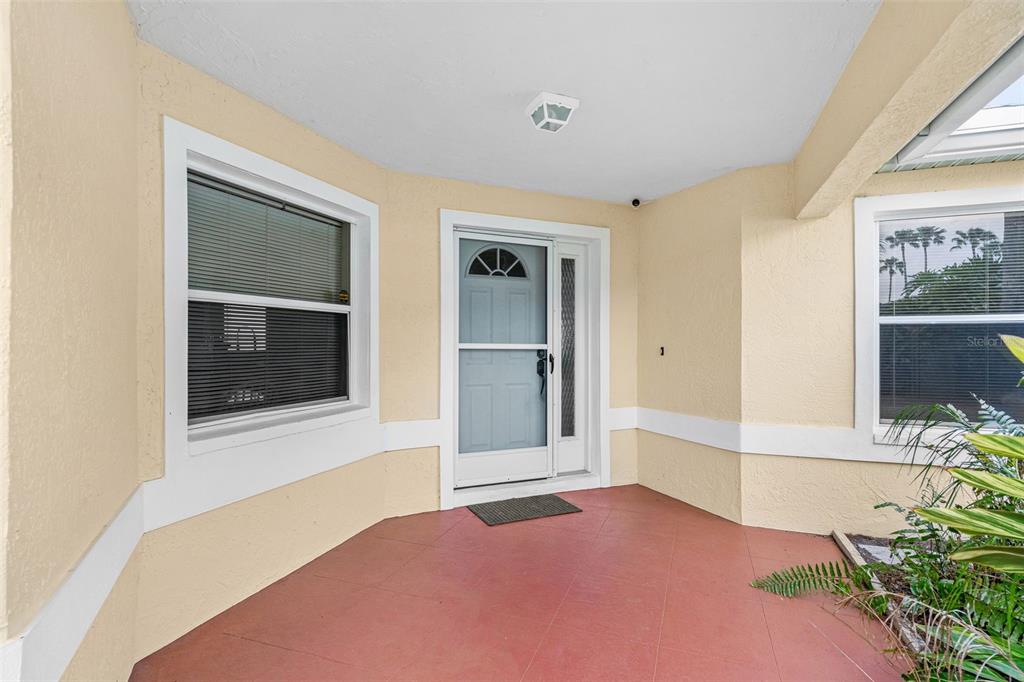 A covered entryway features a light blue front door, white trim, and reddish-brown tile flooring — 2515 LANTANA LANE, PALMETTO, FL