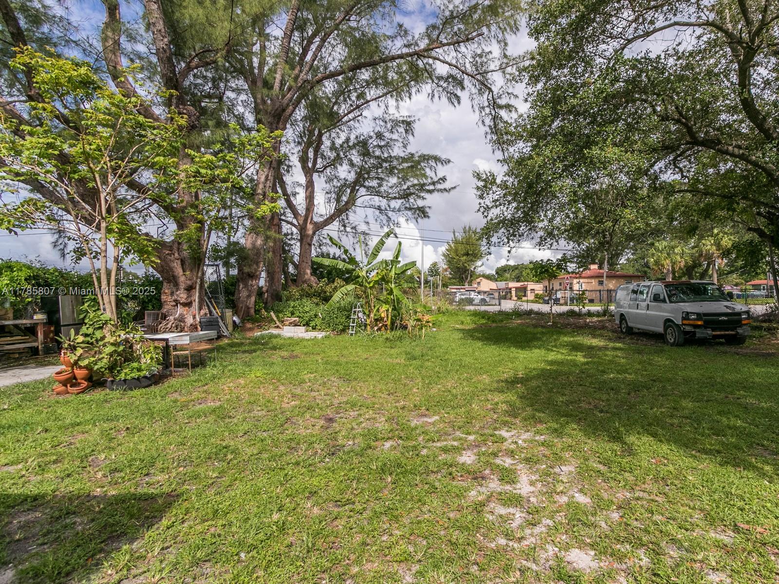 A large grassy backyard features mature trees, a banana plant, and a parked white van — 7946 NW 12th Pl, Miami FL 33147, MIAMI, FL
