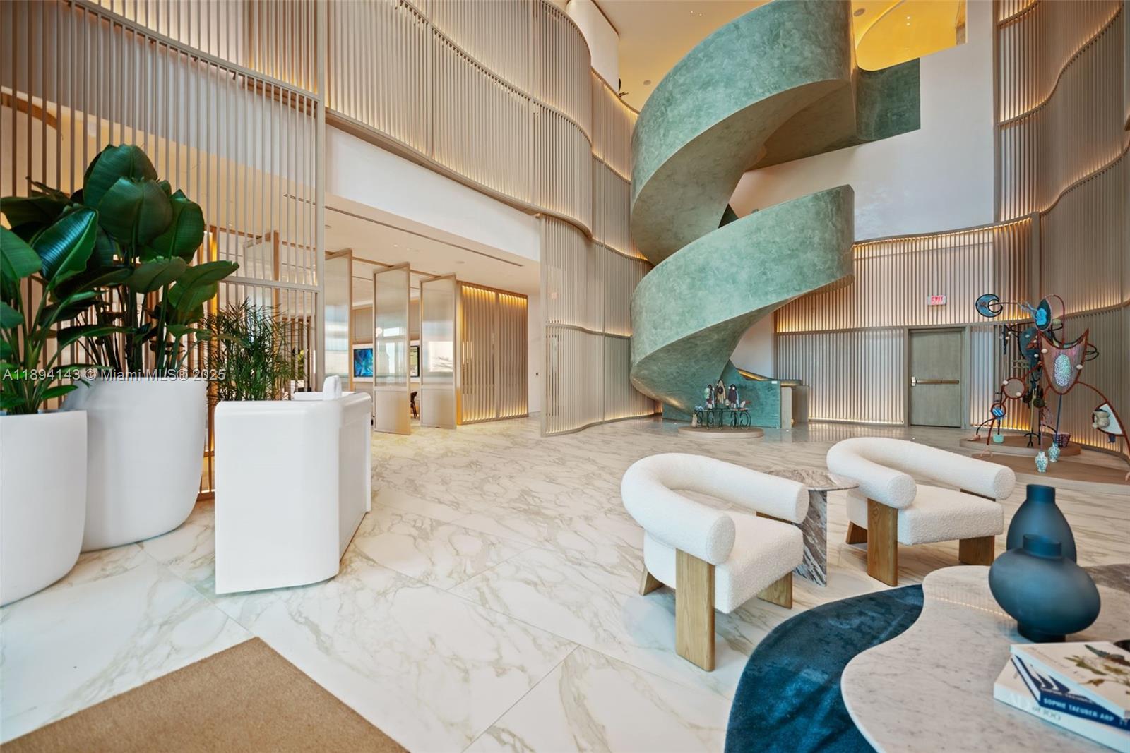 A modern lobby features a large spiral staircase, marble floors, and contemporary white armchairs — 900 N Ocean Blvd # 1005, Pompano Beach FL 33062, POMPANO BEACH, FL