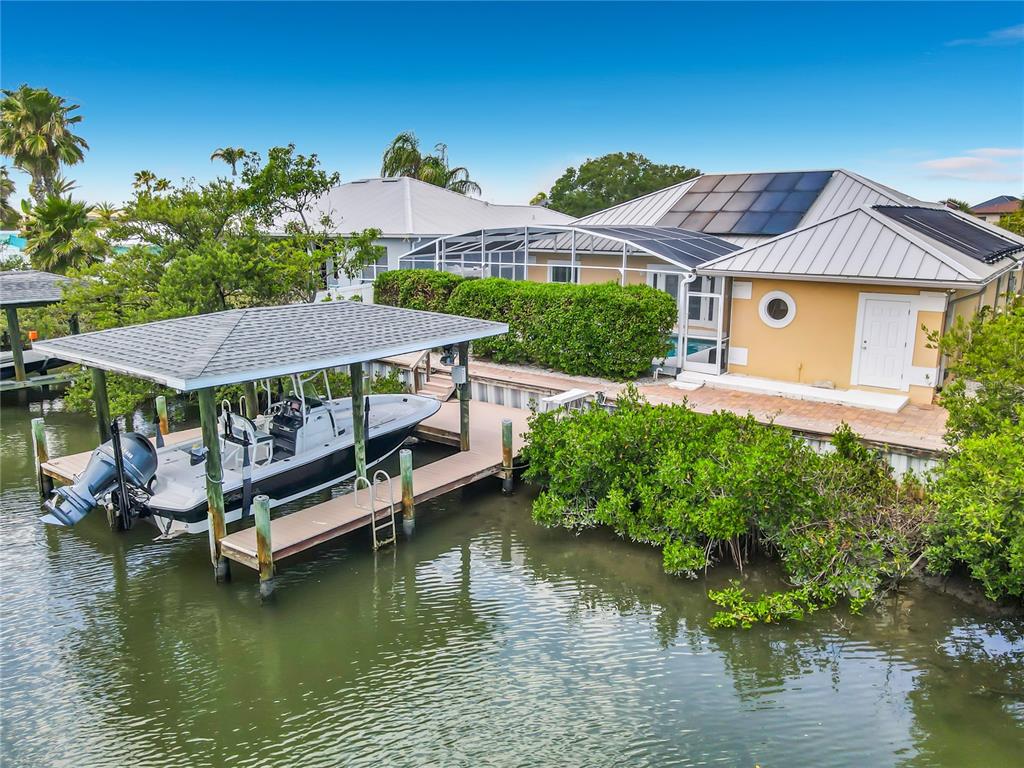 A waterfront house features a boat dock with a covered slip and a swimming pool — 21 RICHMOND DR, NEW SMYRNA BEACH, FL