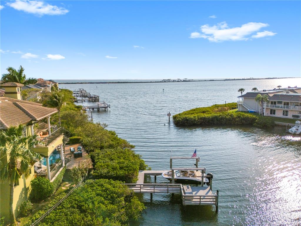 An aerial view shows a waterfront home with a private dock and boat on a canal — 4128 CAUSEWAY VISTA DRIVE, TAMPA, FL