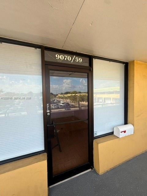 A glass-paned commercial entrance door with the number 9070/59 above it — 9070 Kimberly Blvd # 59, Boca Raton FL 33434, BOCA RATON, FL