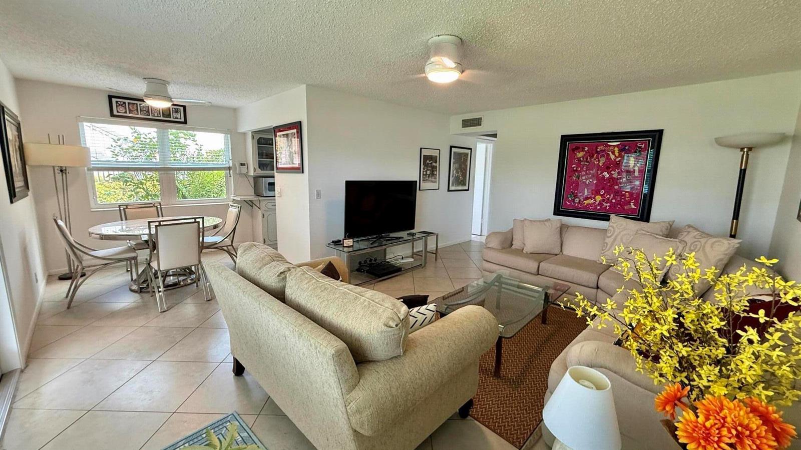 A living room and dining area with tile flooring, beige furniture, and a television — 316 Markham, Deerfield Beach FL 33442, DEERFIELD BEACH, FL