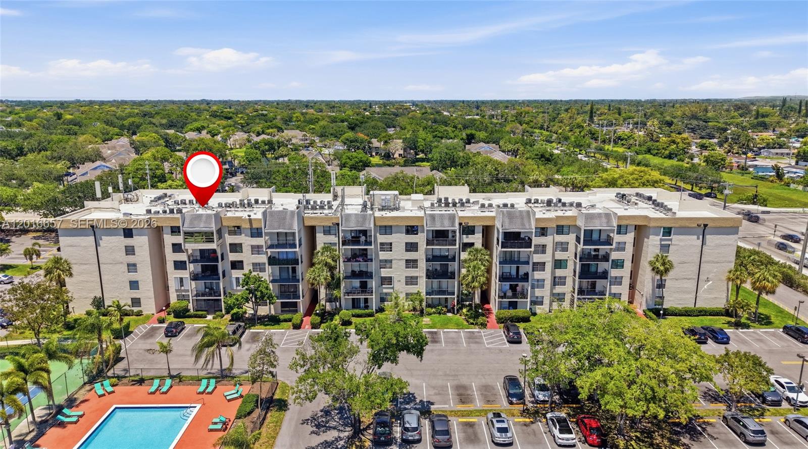 An aerial view shows a multi-story residential apartment building with a swimming pool nearby — 6195 Rock Island Rd # 511, Tamarac FL 33319, TAMARAC, FL