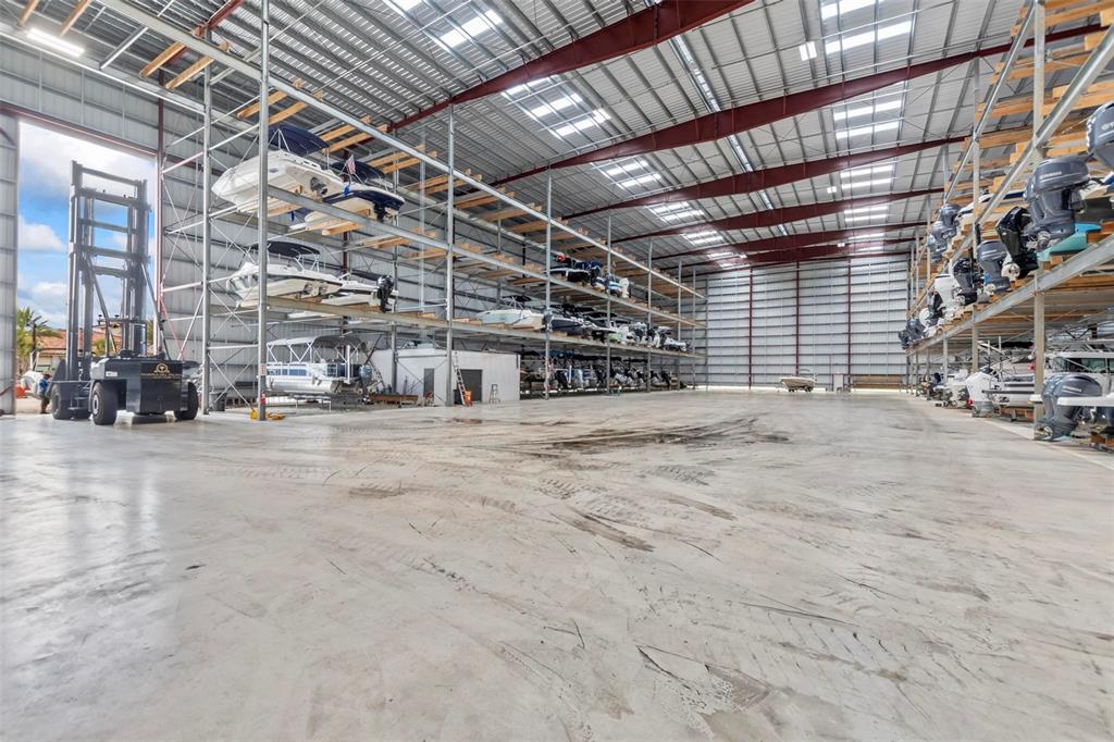 A large indoor boat storage facility with metal racking systems and a forklift — 6 DEL PALMA DRIVE, PALM COAST, FL