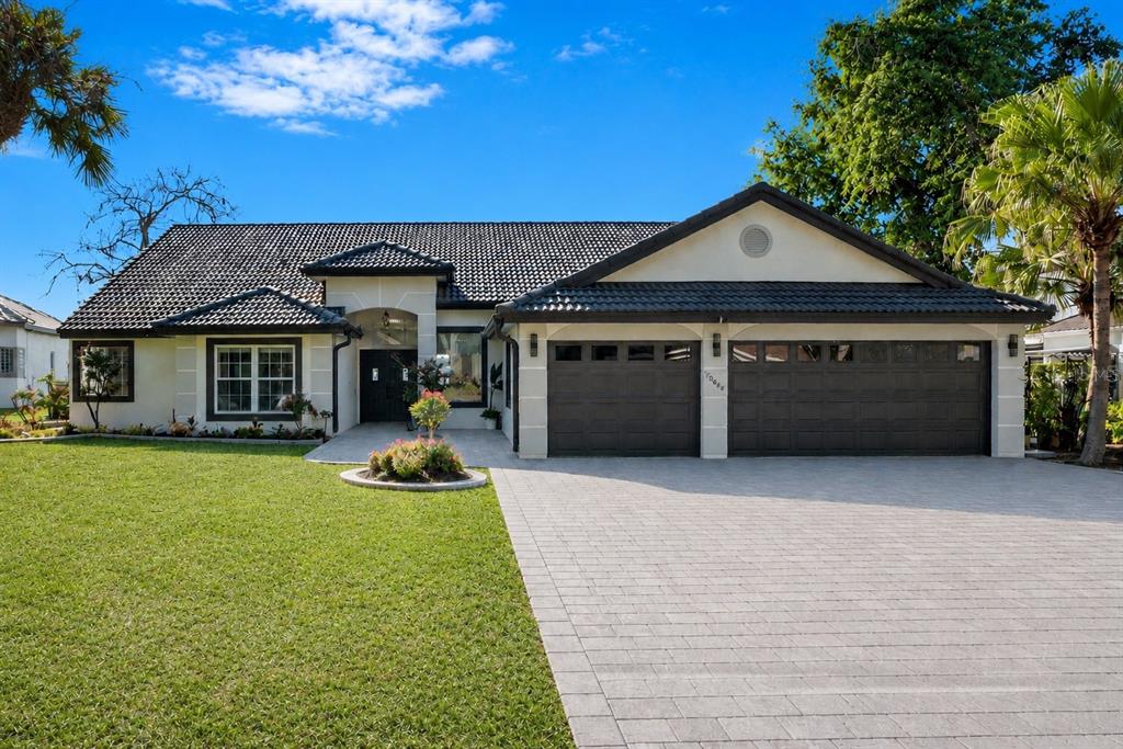 A single-story house with a tiled roof, a paved driveway, and a two-car garage — 10094 BRANDON CIRCLE, ORLANDO, FL