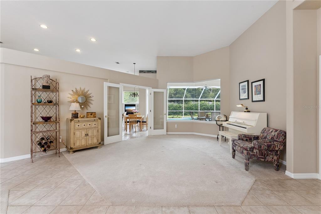 A living room features beige carpet, a white piano, French doors, and a bay window — 3823 WINDING LAKE CIRCLE, ORLANDO, FL