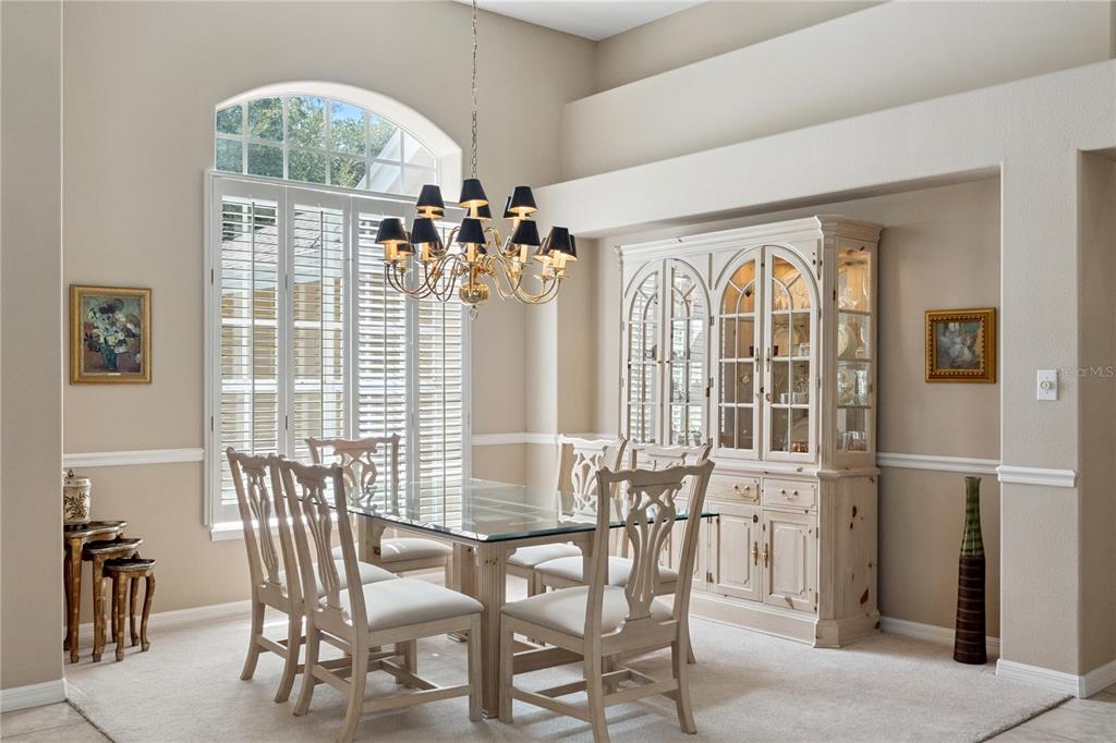 A dining room features a glass-topped table, six chairs, a hutch, and a chandelier — 3823 WINDING LAKE CIRCLE, ORLANDO, FL