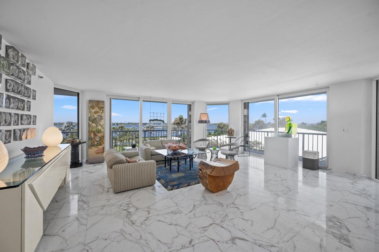 A bright living room features white marble floors, floor-to-ceiling windows, and views of the water — 3170 S Ocean Boulevard # 305s, Palm Beach FL 33480, PALM BEACH, FL