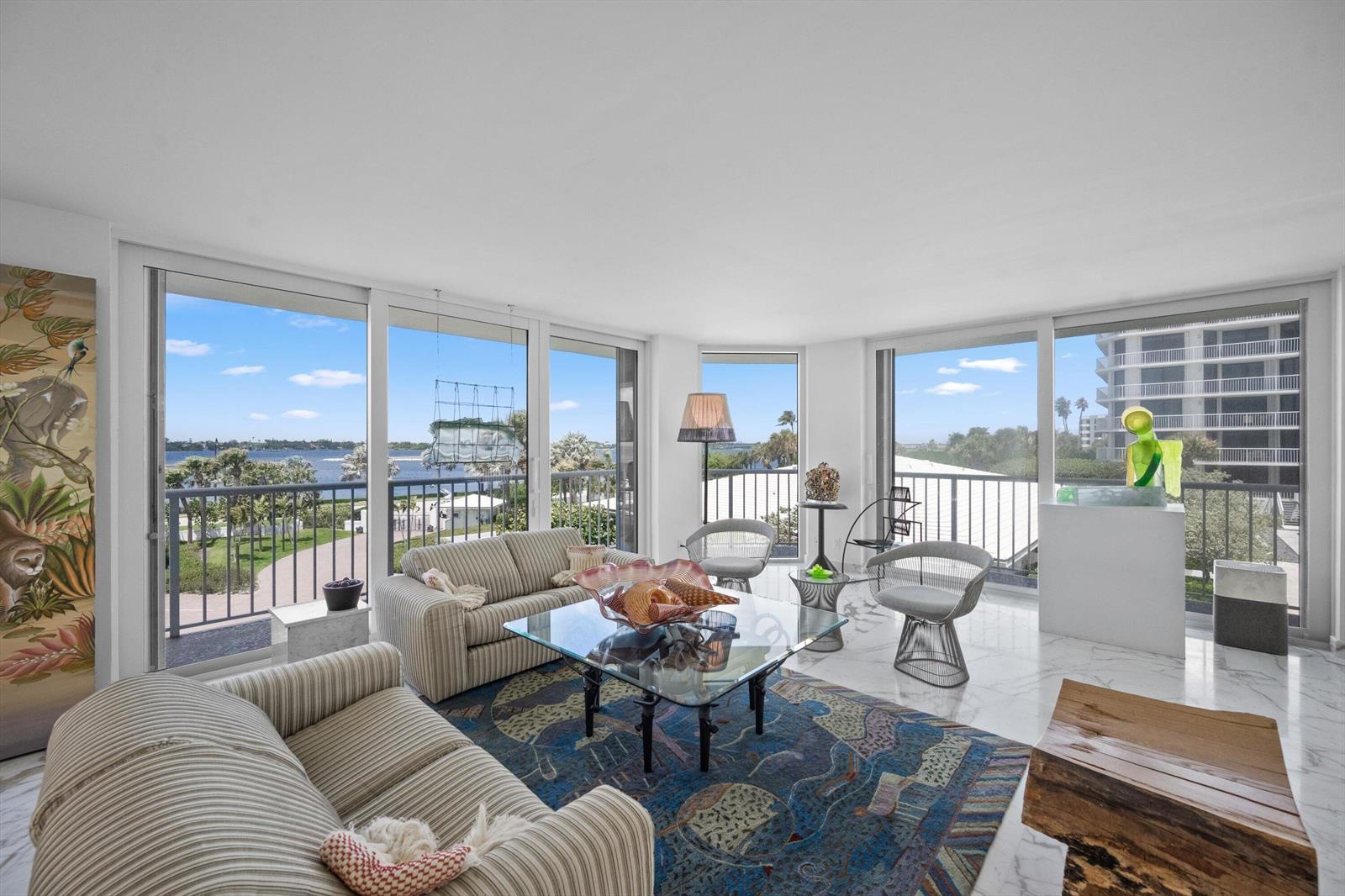 A bright living room features marble floors, striped sofas, a glass coffee table, and balcony views — 3170 S Ocean Boulevard # 305s, Palm Beach FL 33480, PALM BEACH, FL