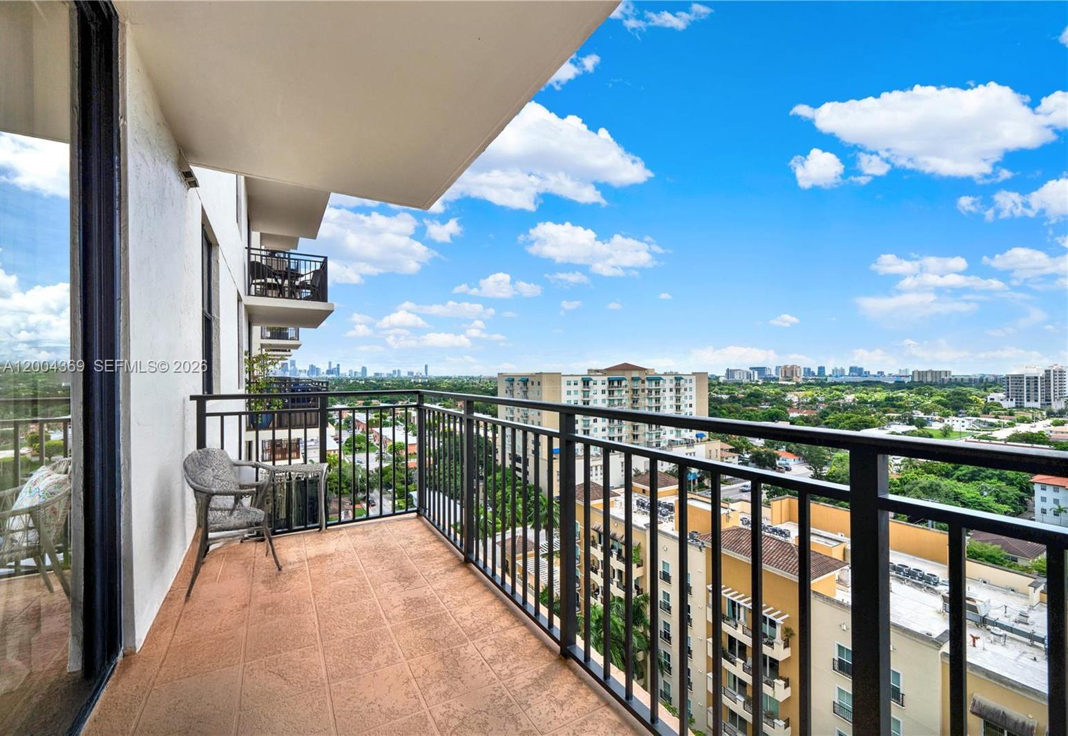 A high-rise balcony features tiled flooring, a metal railing, and an expansive city view — 888 S Douglas Rd # 1512, Coral Gables FL 33134, CORAL GABLES, FL