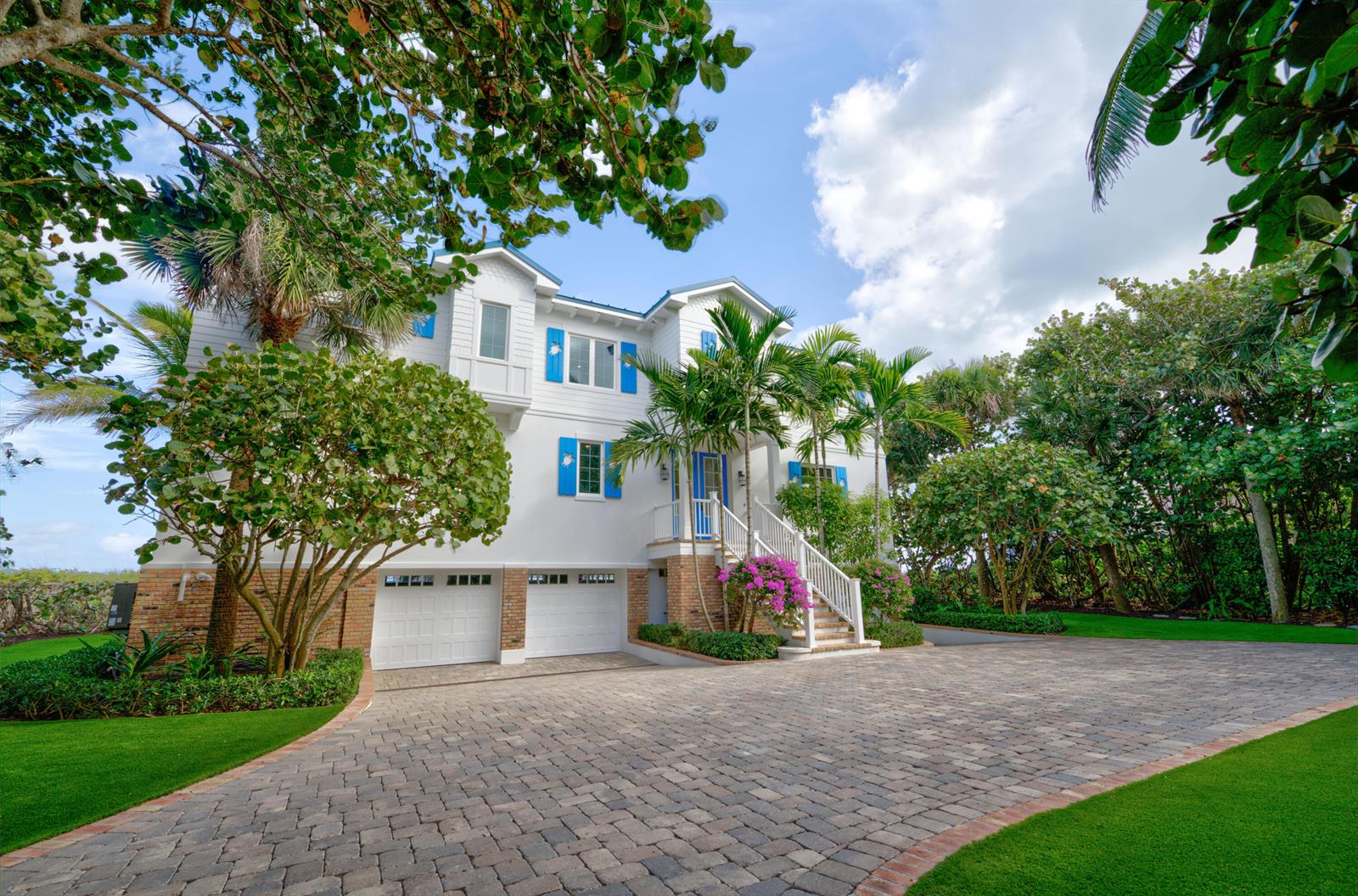 A three-story white house with blue shutters and a brick-paved driveway surrounded by trees — 113 N Beach Road, Jupiter Island FL 33455, JUPITER ISLAND, FL