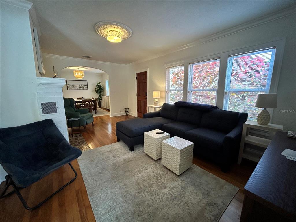 A living room features hardwood floors, a dark sectional sofa, and an arched entryway — 701 29TH AVENUE N, ST PETERSBURG, FL