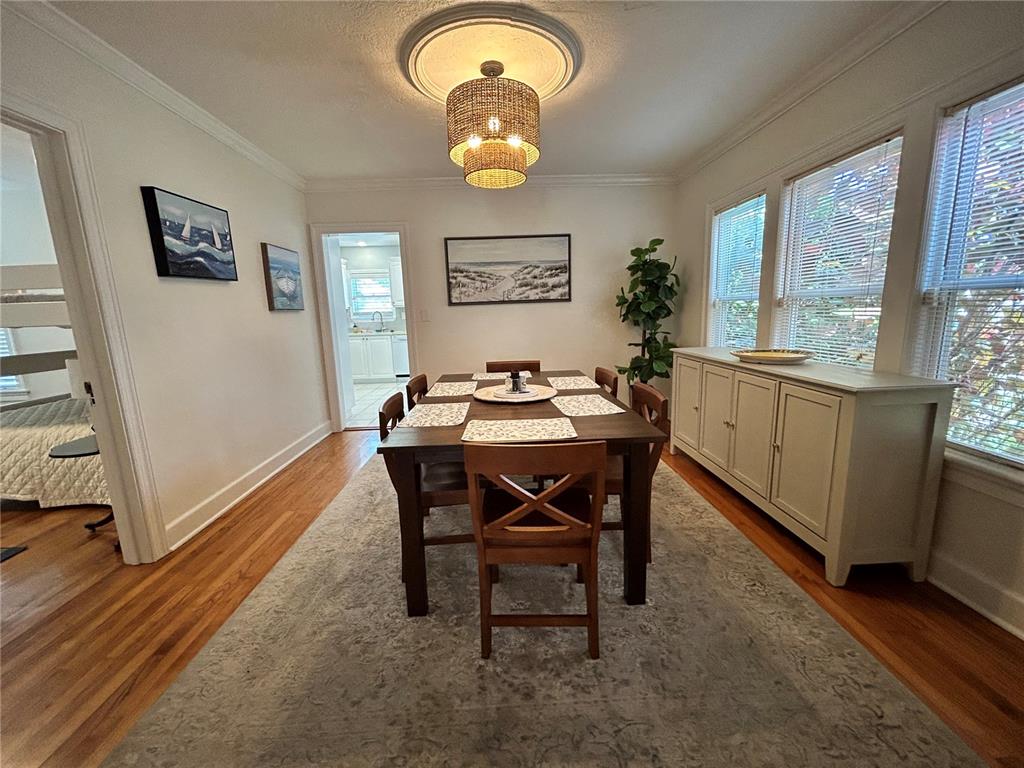 A dining room features a wooden table, chairs, a sideboard, and a woven pendant light — 701 29TH AVENUE N, ST PETERSBURG, FL