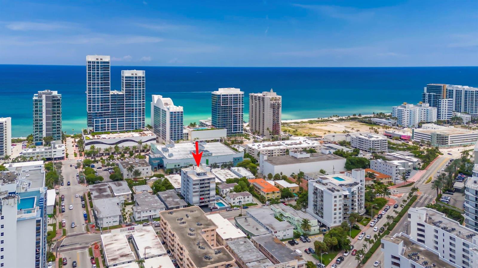 An aerial view shows a multi-story residential building highlighted by a red arrow near the beach — 6855 Abbott Avenue # 201, Miami Beach FL 33141, MIAMI BEACH, FL