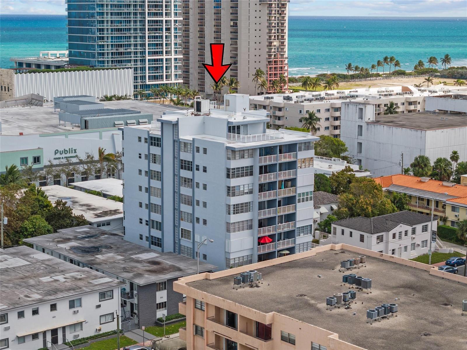 An aerial view shows a light blue apartment building with balconies near a beach — 6855 Abbott Avenue # 201, Miami Beach FL 33141, MIAMI BEACH, FL