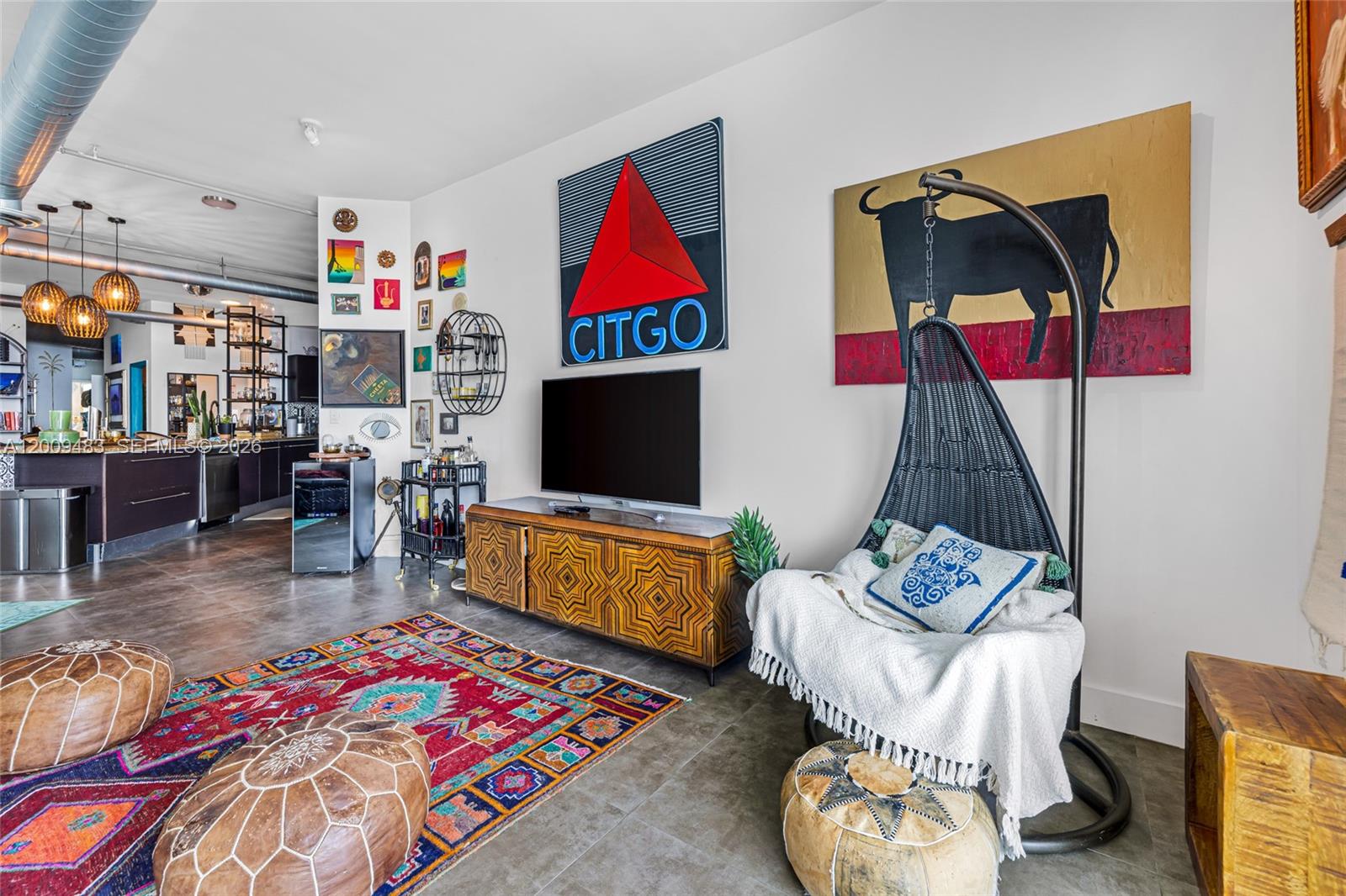A living room features a hanging chair, a patterned rug, and a Citgo sign — 700 NE 25th St # 1104, Miami FL 33137, MIAMI, FL