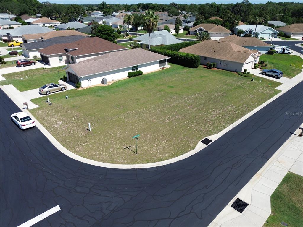 An aerial view shows a vacant corner residential lot situated between two existing houses — 3756 E KIWI COVE COURT, HERNANDO, FL