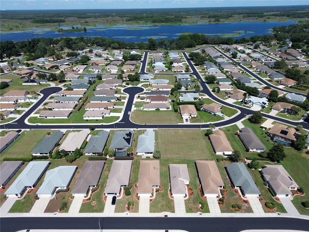 An aerial view shows a suburban neighborhood with single-family homes near a large lake — 3756 E KIWI COVE COURT, HERNANDO, FL