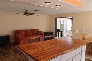 A living room features a red sofa, wood flooring, and a large kitchen island — 3601 62ND STREET W, BRADENTON, FL