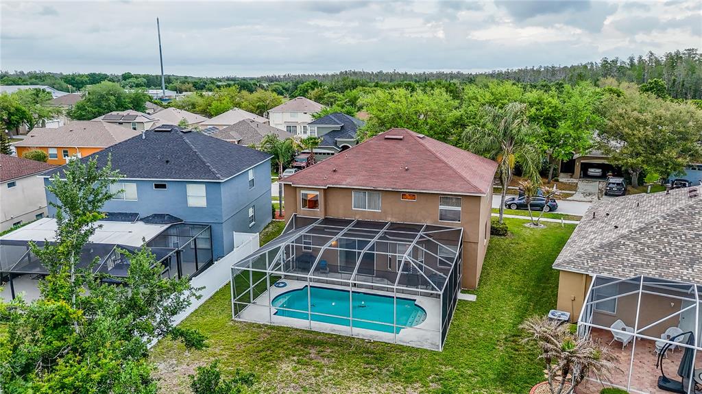 An aerial view shows two-story houses with screened-in swimming pools in a suburban neighborhood — 10526 BENEVA DRIVE, TAMPA, FL