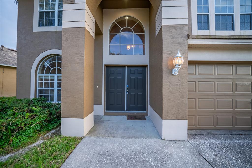 A two-story house exterior features a double front door, arched windows, and a garage — 10526 BENEVA DRIVE, TAMPA, FL