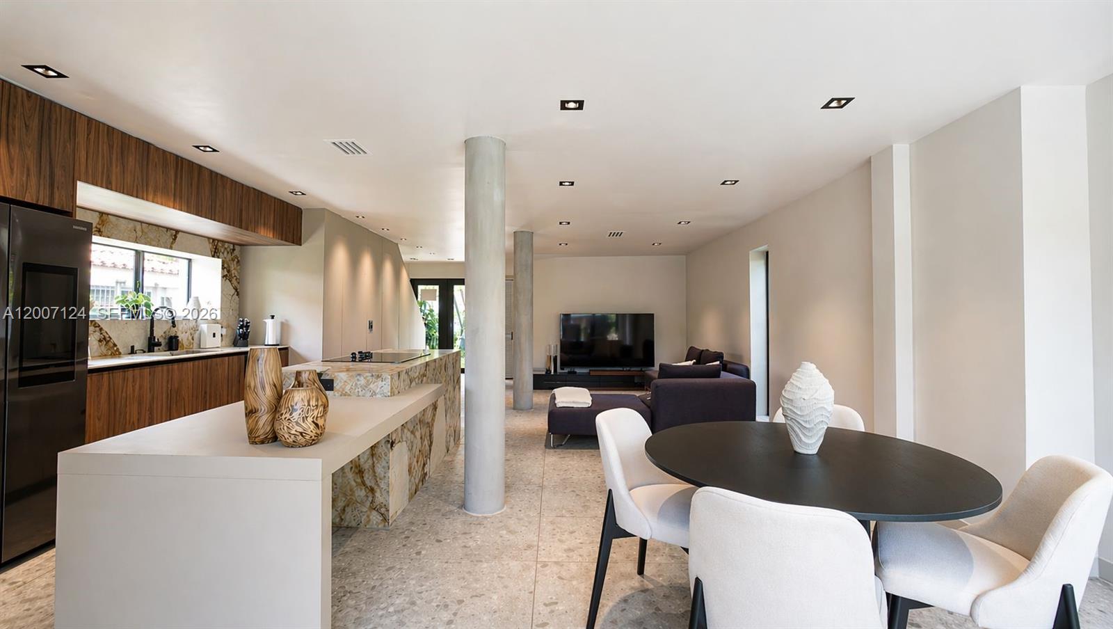 An open-concept living area features a kitchen with stone counters, concrete columns, and a dining set — 1820 SW 10th St, Miami FL 33135, MIAMI, FL