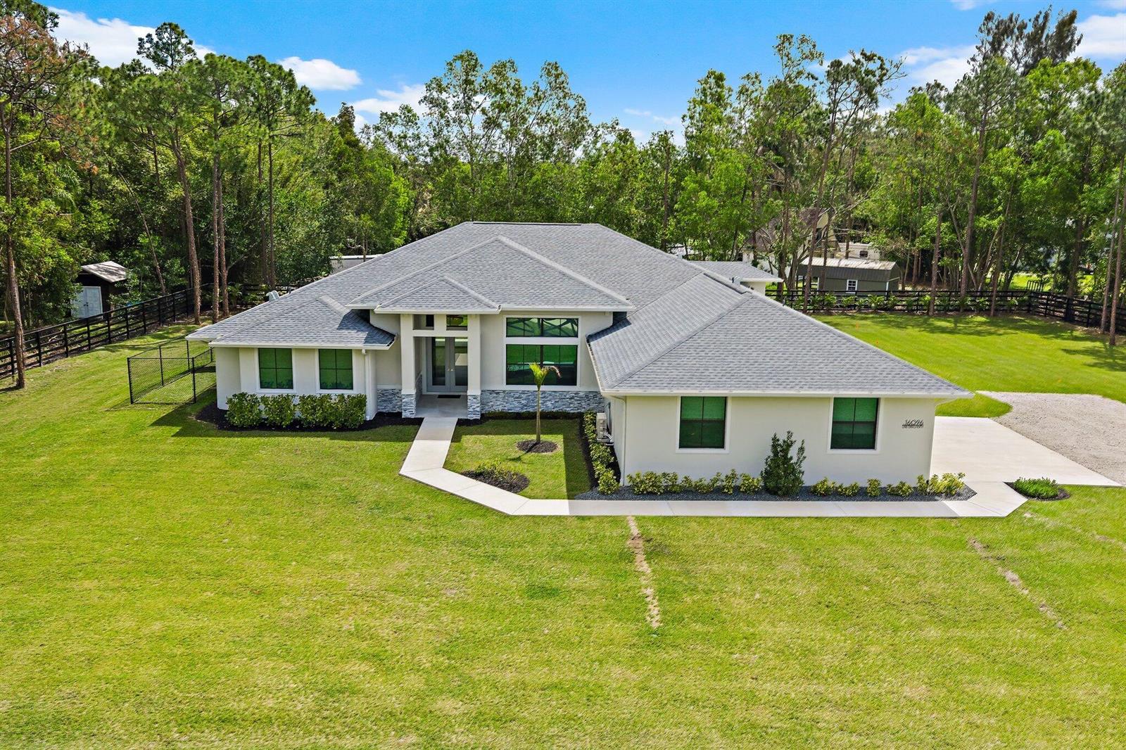 An aerial view of a single-story house with a gray roof and a large lawn — 16096 132nd Terrace N, Jupiter FL 33478, JUPITER, FL