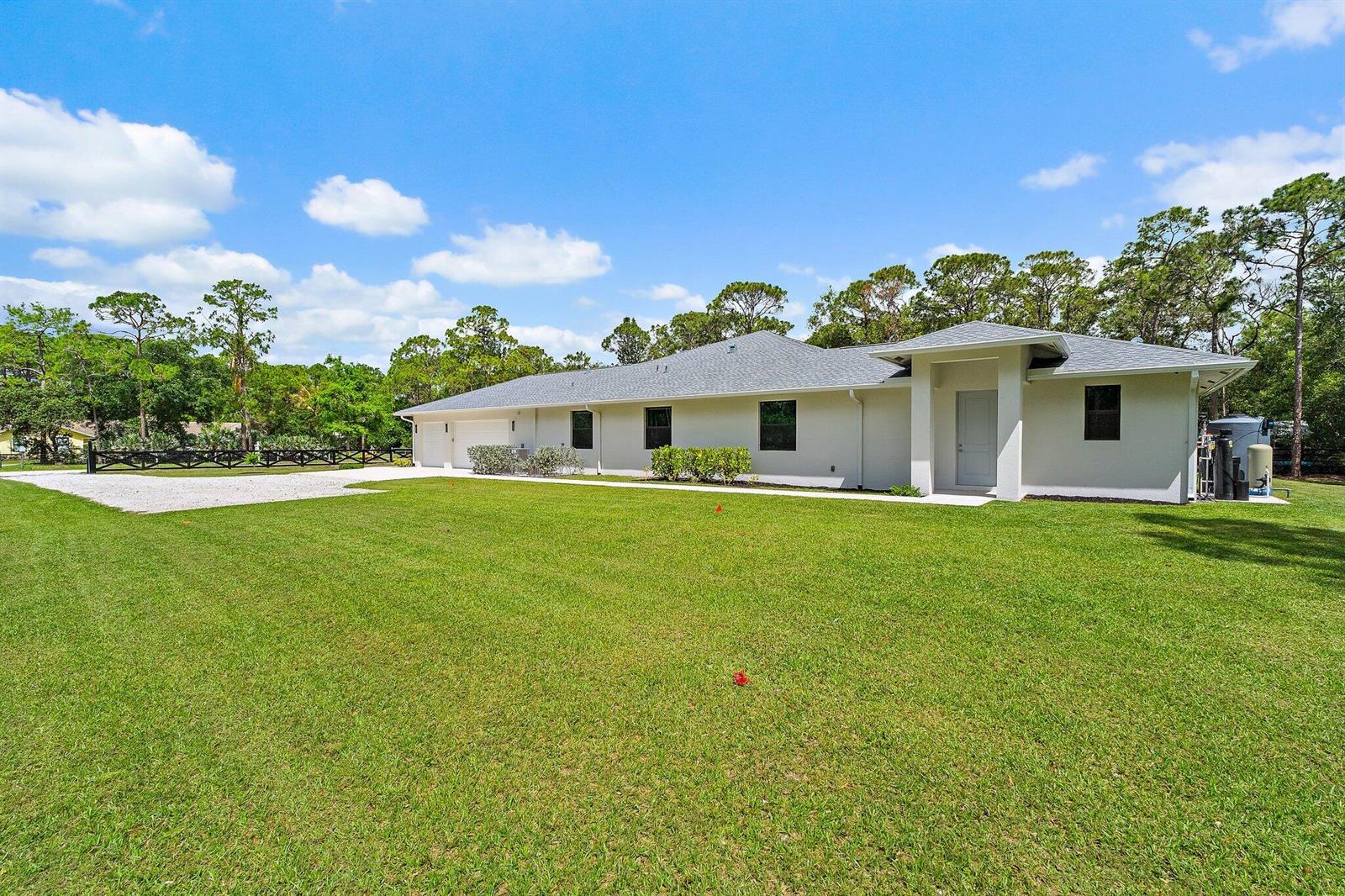 A single-story house with a white exterior, gray roof, and a large front lawn — 16096 132nd Terrace N, Jupiter FL 33478, JUPITER, FL