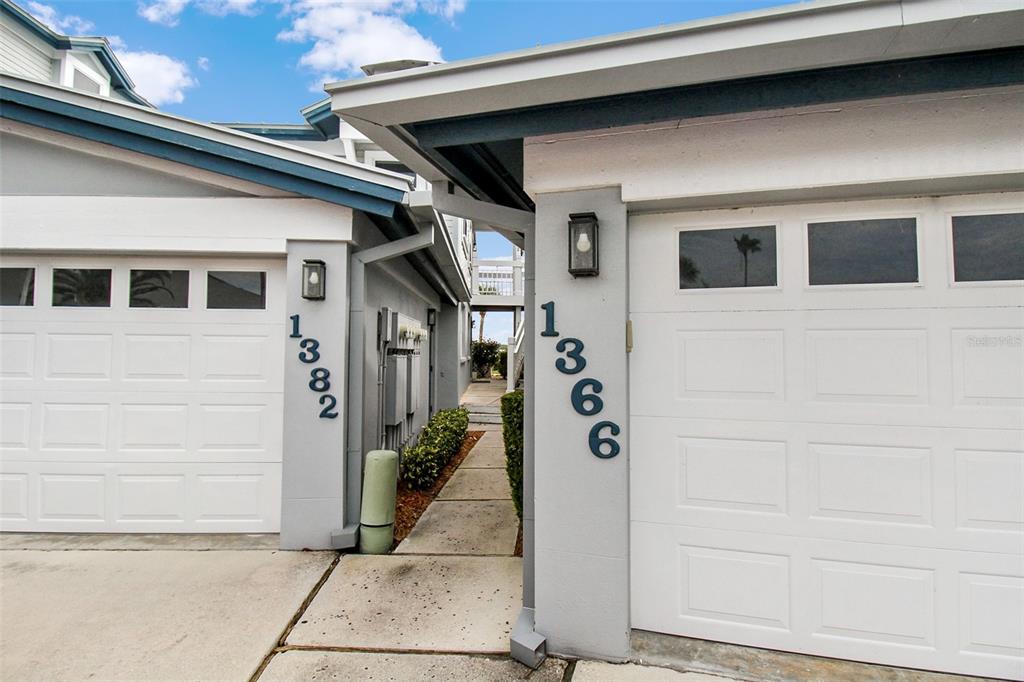 Two adjacent garage doors with house numbers displayed on the pillars and a central walkway — 1366 SIESTA BAYSIDE DRIVE UNIT 1366-F, SARASOTA, FL