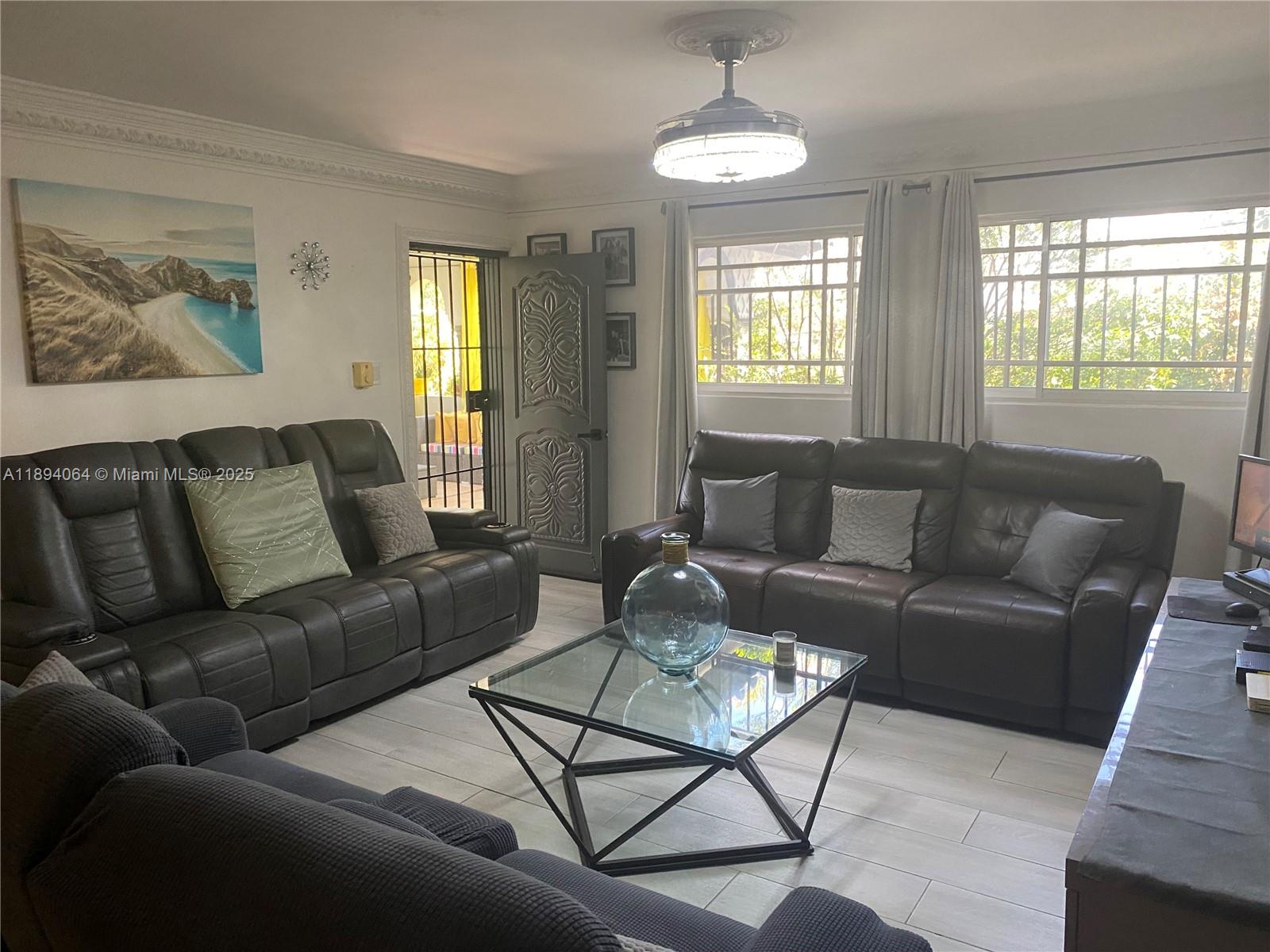 A living room features dark leather sofas, a glass coffee table, and white tile flooring — 6 CALLE 29 ESTE, NY 10133, NY