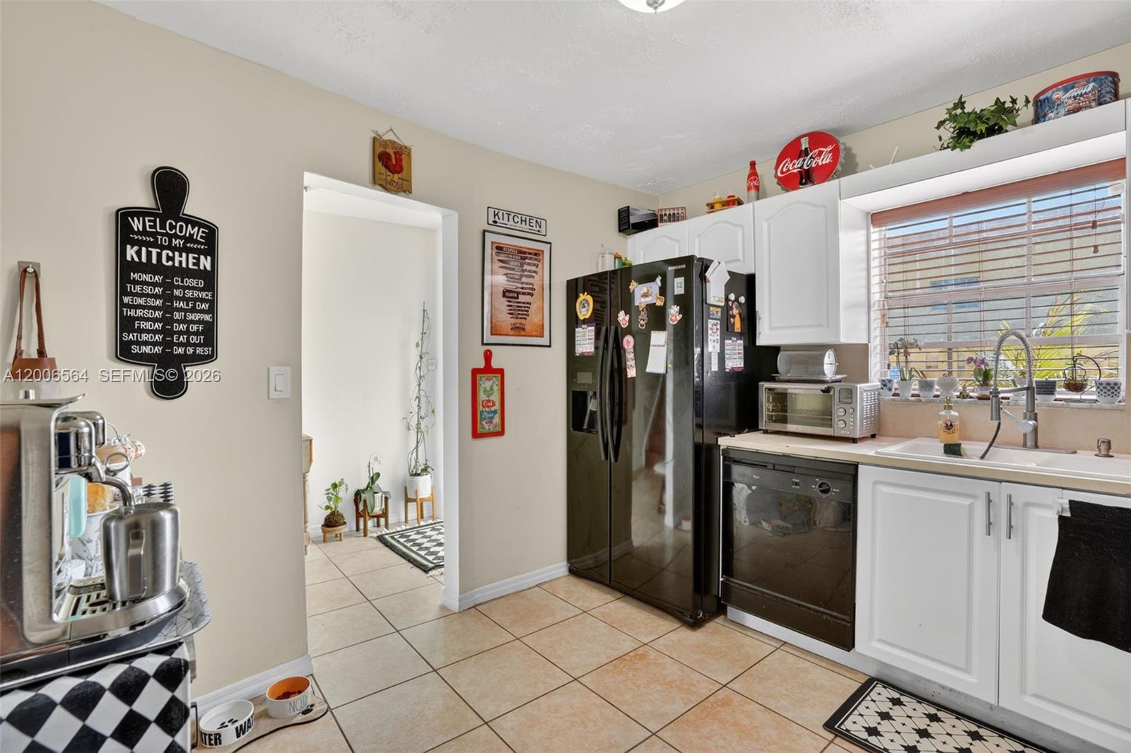 A kitchen features white cabinets, a black refrigerator, a dishwasher, and tan floor tiles — 8330 SW 154th Ave # 35, Miami FL 33193, MIAMI, FL