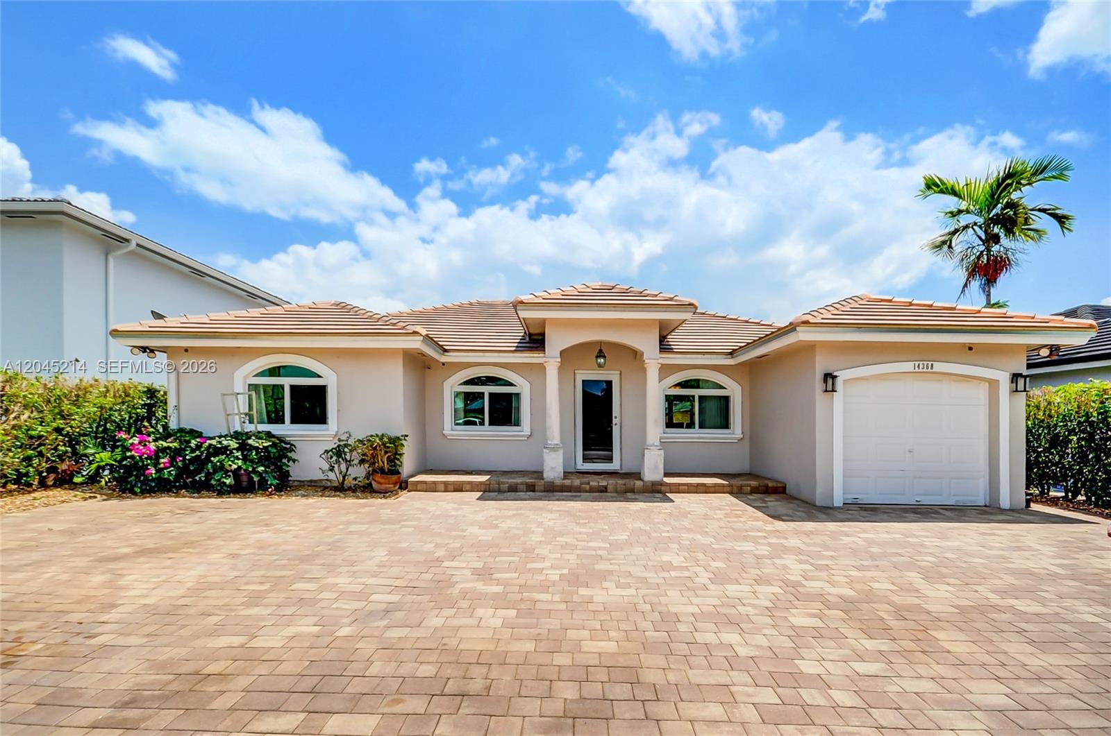 A single-story house with a beige stucco exterior, tiled roof, and a paved driveway — 14368 SW 165th St, Miami FL 33177, MIAMI, FL