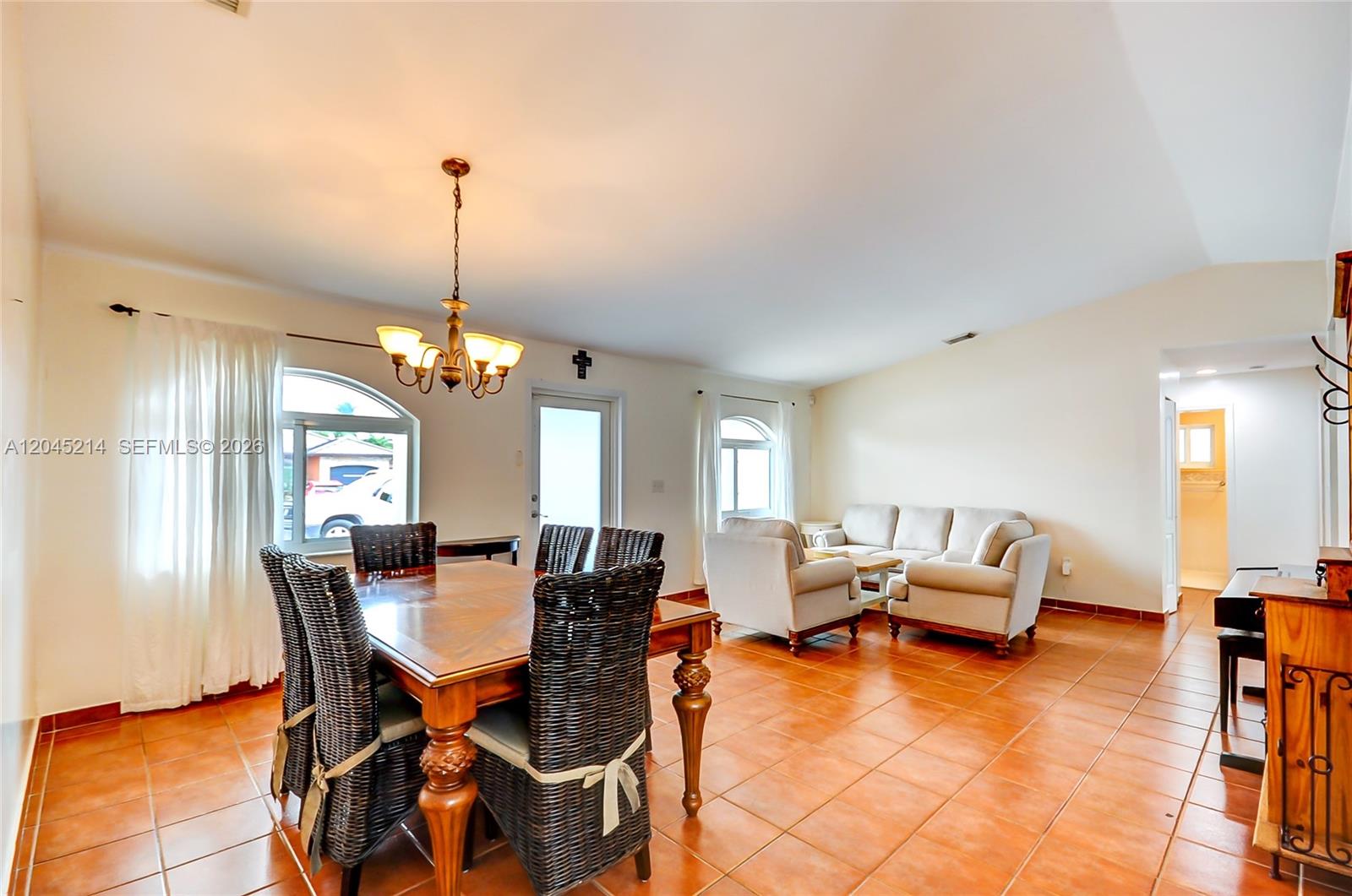 A dining and living area features tile floors, a wooden table, and beige upholstered furniture — 14368 SW 165th St, Miami FL 33177, MIAMI, FL