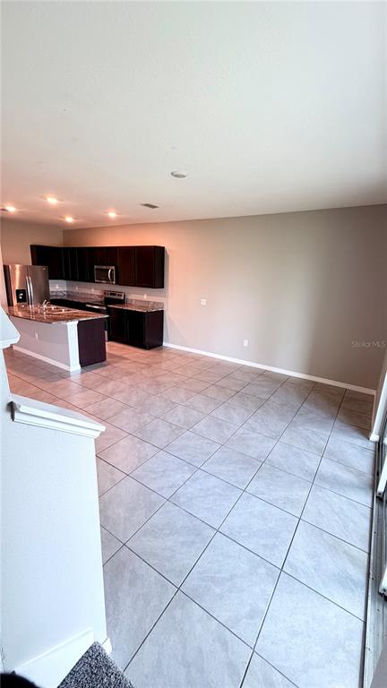 A hallway with arched entryways, tile flooring, and white doors leads to an exterior door — 5254 DRAGONFLY DRIVE, WILDWOOD, FL
