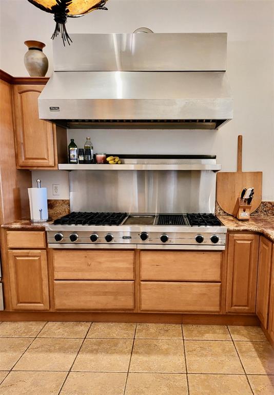 A kitchen features a stainless steel Viking range and hood with light wood cabinetry — 807 NEPTUNE ROAD, KISSIMMEE, FL