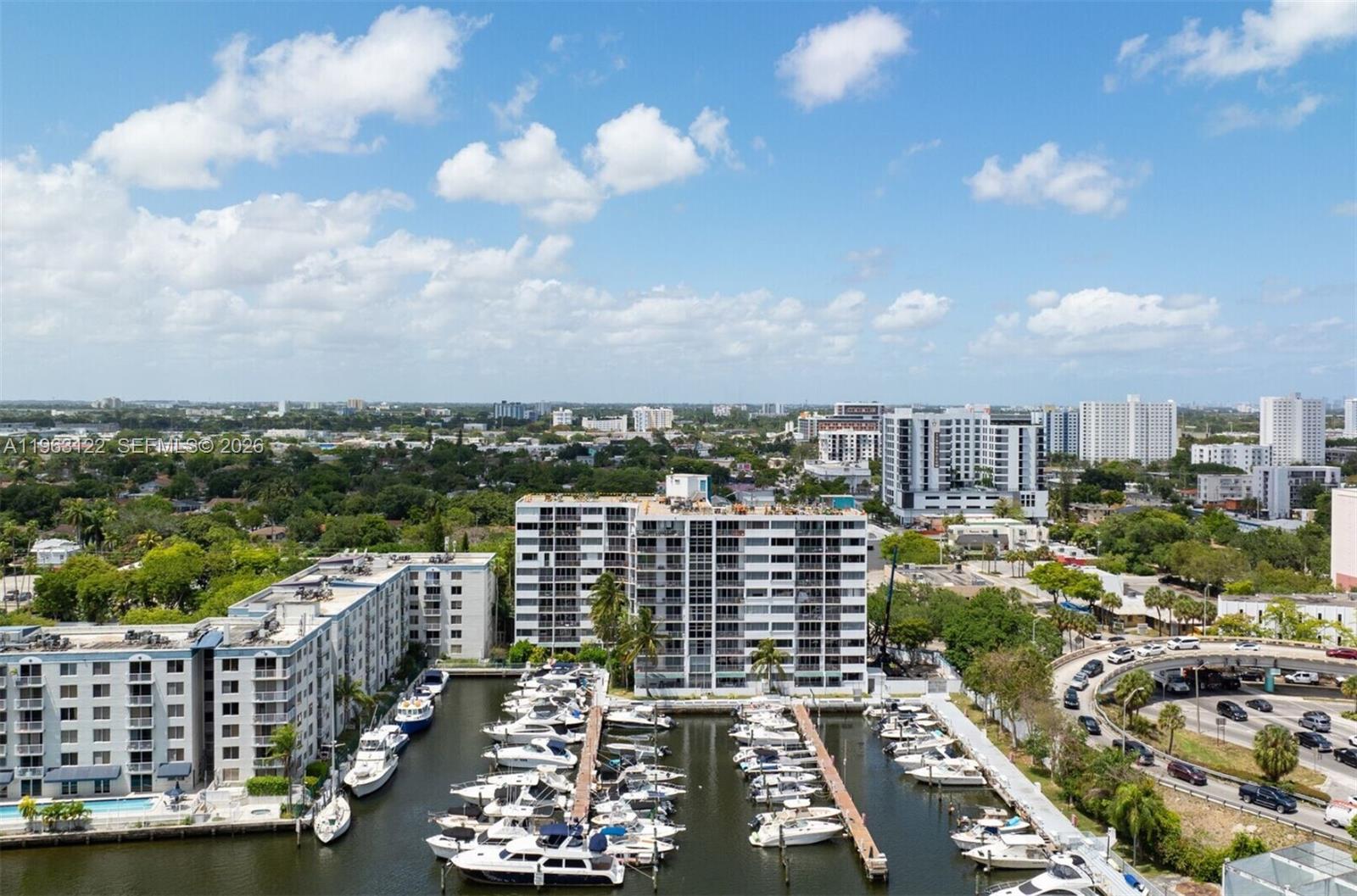 An aerial view shows a marina with docked boats beside residential apartment buildings — 1700 NW N River Dr, Miami FL 33125, MIAMI, FL