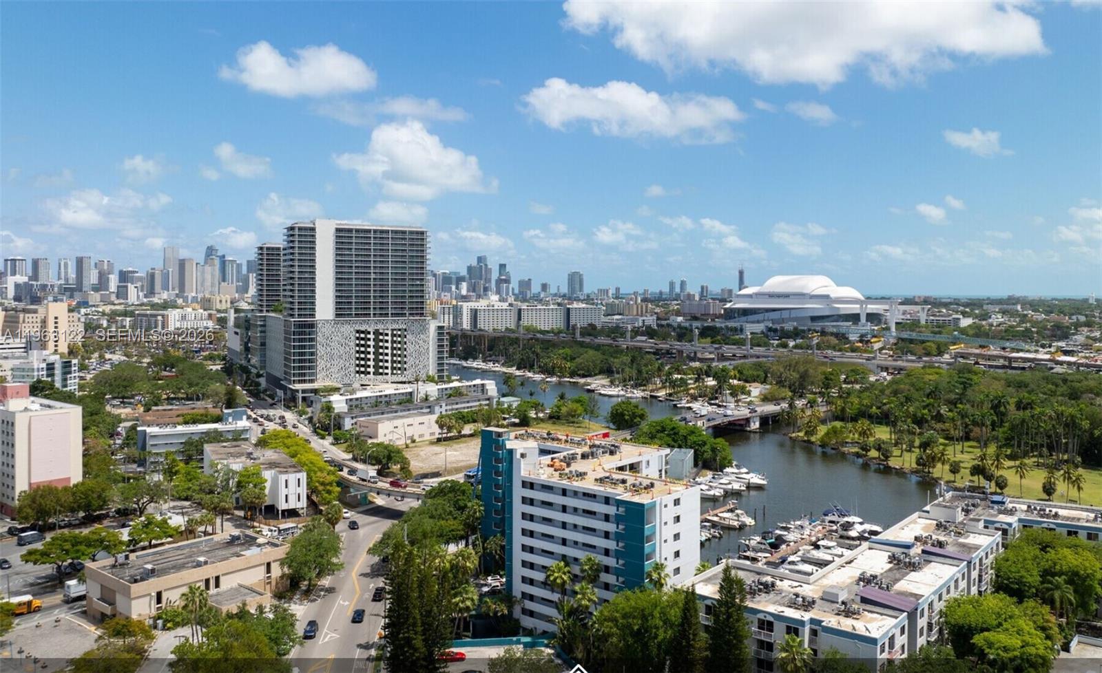 An aerial view shows a city skyline, a river with boats, and surrounding residential buildings — 1700 NW N River Dr, Miami FL 33125, MIAMI, FL