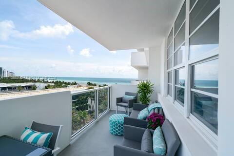 A balcony with outdoor seating overlooks the ocean and a coastal landscape — 100 Lincoln Rd # 739, Miami Beach FL 33139, MIAMI BEACH, FL