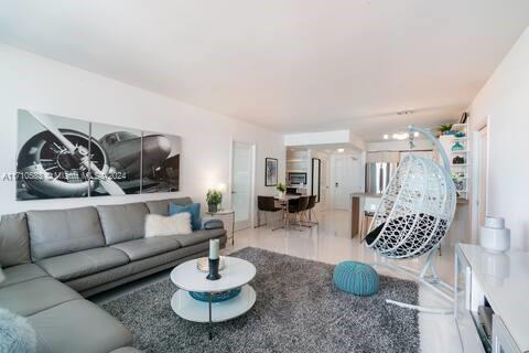 A modern living room features a gray sectional sofa, a round coffee table, and a hanging chair — 100 Lincoln Rd # 739, Miami Beach FL 33139, MIAMI BEACH, FL