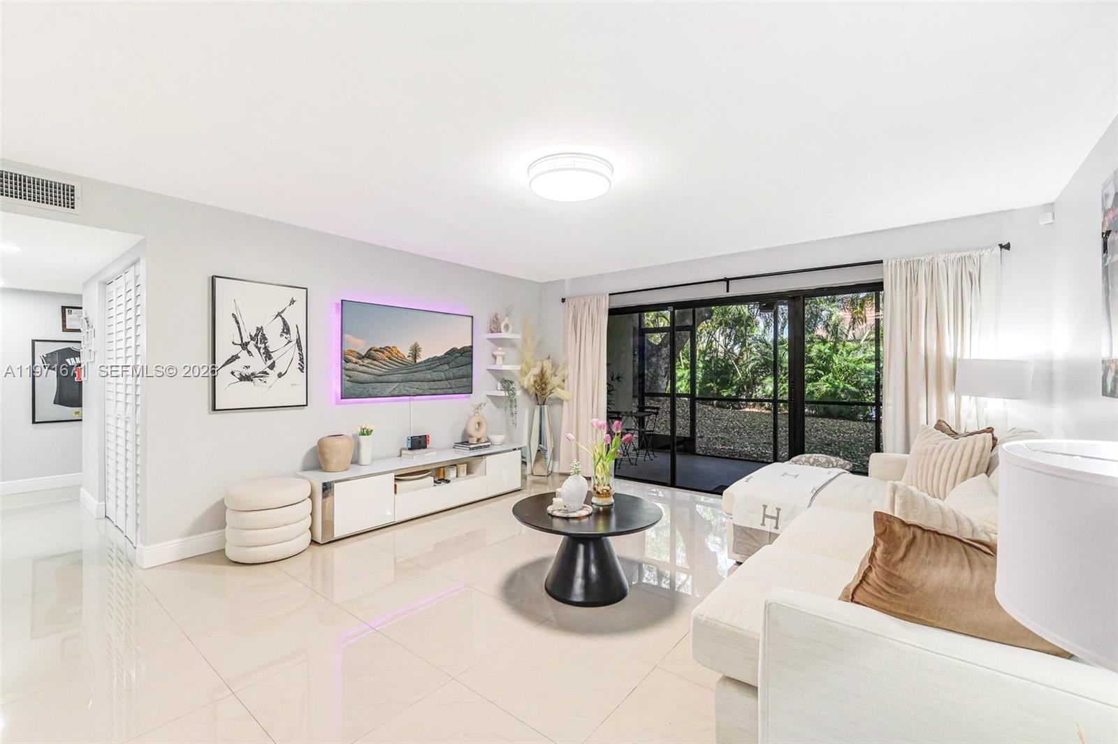 A modern living room features a white sectional sofa, a black coffee table, and tile flooring — 601 Ives Dairy Rd # 00, Miami FL 33179, MIAMI, FL